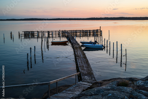 Boats resting peacefully in a small harbor near Gothenburg during a vibrant sunset photo