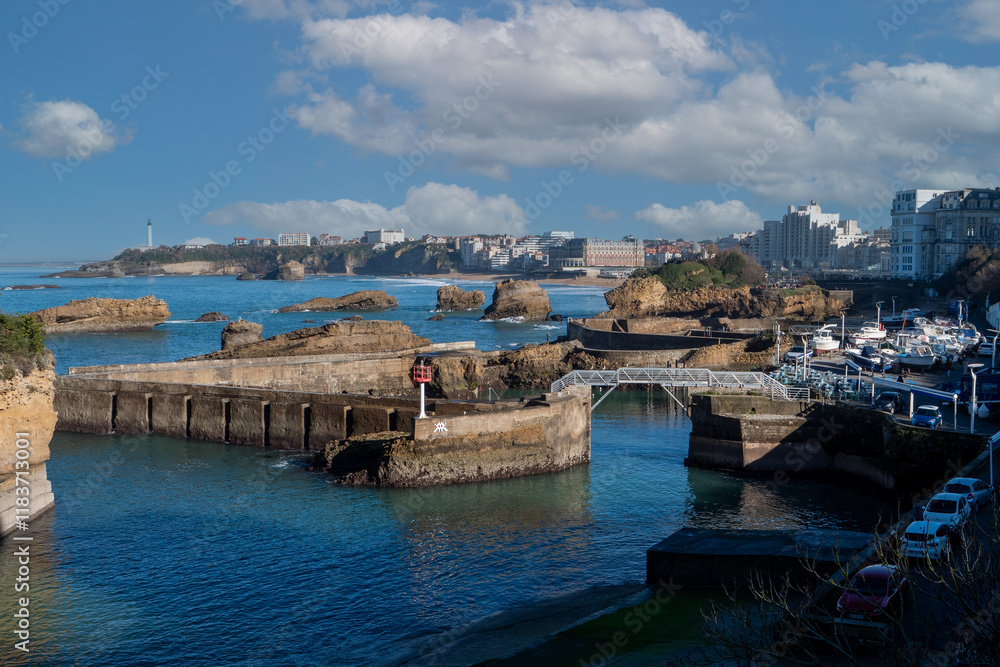 Beautiful blue ocean with a red sign on the pier. The pier is full of boats and the sky is clear. Biarritz, France, Beautiful blue ocean with a red sign on the pier. The pier is full of boats and the sky is clear. Biarritz, France,