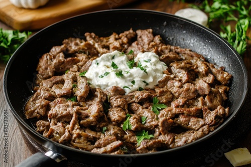 Homemade gyros Greek meat dish in skillet on table