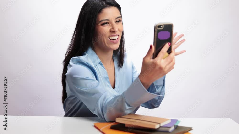 Latin woman making a video call on white background in slow motion Latin woman making a video call on white background in slow motion