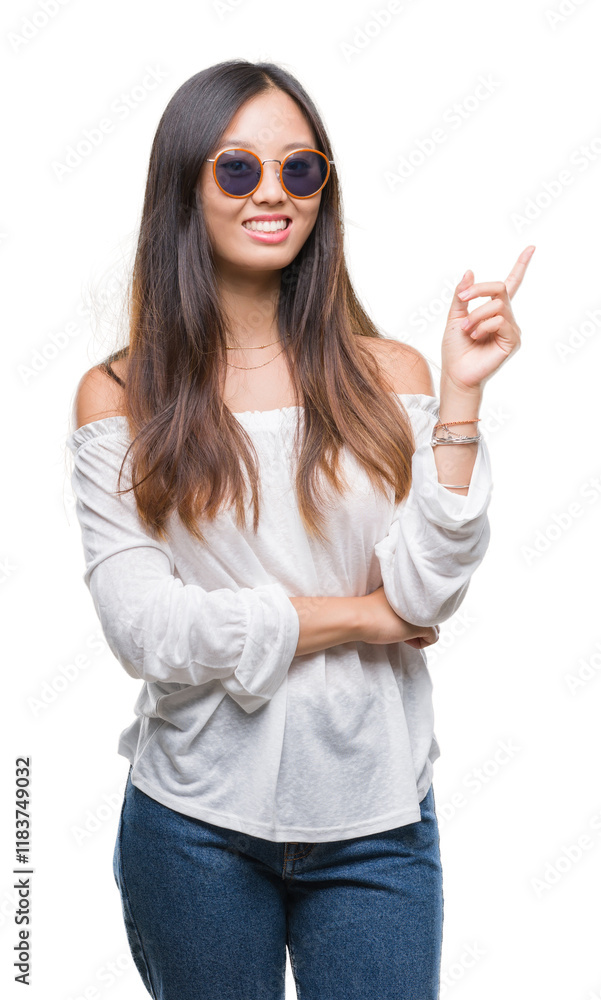Young asian woman wearing sunglasses over isolated background with a big smile on face, pointing with hand and finger to the side looking at the camera. Young asian woman wearing sunglasses over isolated background with a big smile on face, pointing with hand and finger to the side looking at the camera.