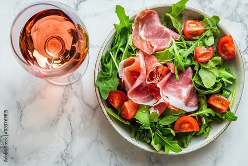 Tasty salad with prosciutto and arugula on a pale marble backdrop Healthy eating idea Italian food Vertical orientation photo