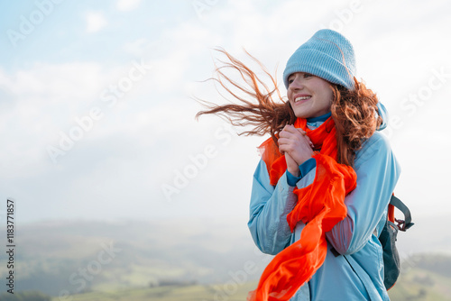 Canvastavla Joyful woman enjoying a windy day on a mountain summit with vibrant scarf