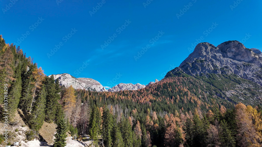 Majestic autumn landscape in the Italian Alps, showcasing vibrant trees and towering mountains, embodying nature's beauty and tranquility Majestic autumn landscape in the Italian Alps, showcasing vibrant trees and towering mountains, embodying nature's beauty and tranquility