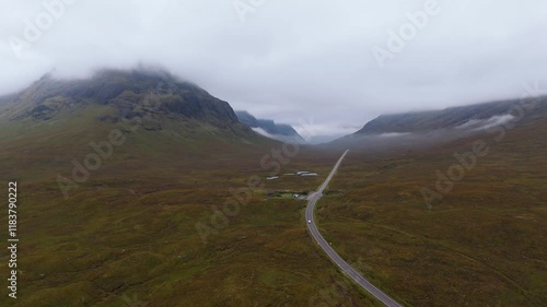 Aerial drone footage of the A82 road in Glencoe mountain range in the Scottish Highlands, taken in summer on a clear but misty day, morning time. photo