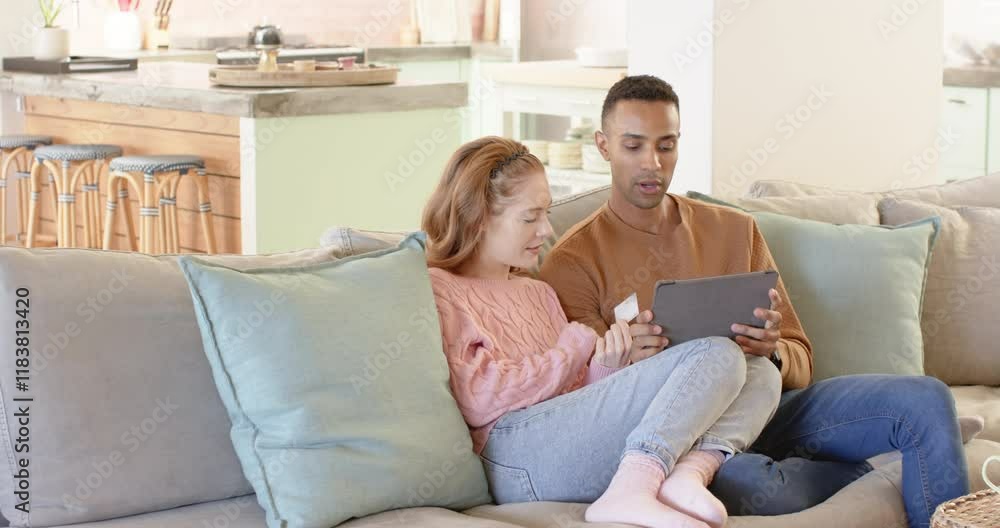 Couple shopping online with tablet and credit card, relaxing on cozy sofa, copy space Couple shopping online with tablet and credit card, relaxing on cozy sofa, copy space