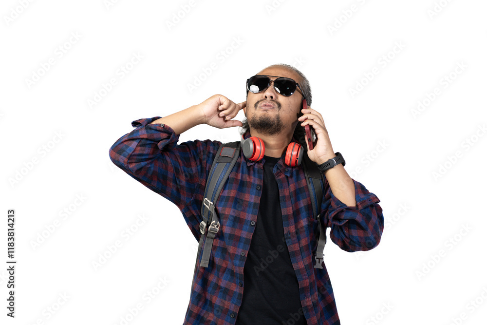 Indonesian curly haired male backpacker is on a voice call while looking at the time on his watch, travel concept, isolated on white background. Indonesian curly haired male backpacker is on a voice call while looking at the time on his watch, travel concept, isolated on white background.