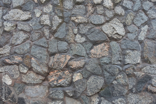 Surface of wall made of gray natural shape fieldstones photo