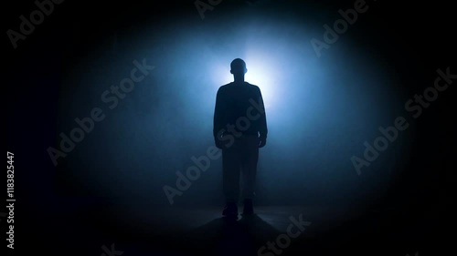silhouette of a man posing in dark space with bright backlight. High quality 4k footage