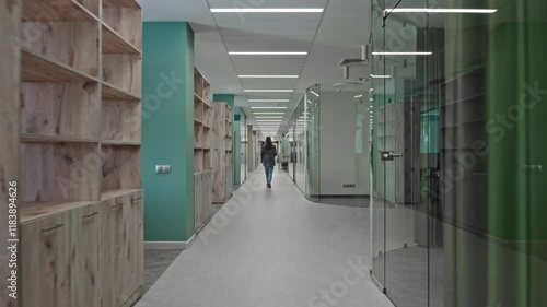 The camera moves around a modern office space, on the left and right are meeting rooms, offices and cabinets. Business commercial real estate.