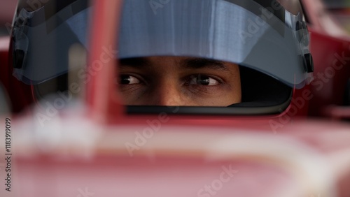 Close-up of a focused pilot driver in a red racing car, preparing for a race