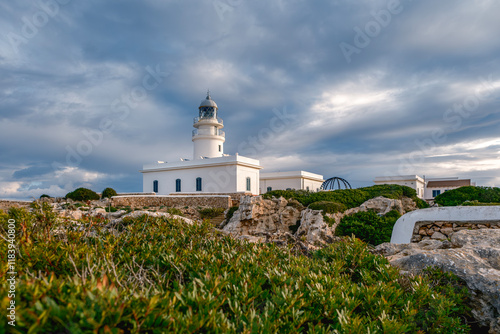 Obraz na płótnie View from the rocks off the coast of the Cap de Cavalleria lighthouse on the north coast of Menorca (Balearic Islands) during a summer day with dramatic cloudy sky, Minorca, Spain. w salonie