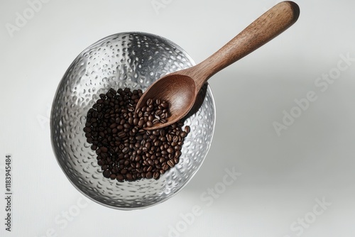 Roasted coffee beans in a metallic bowl with wooden spoon photo