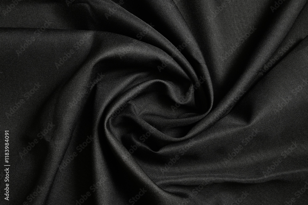 Obraz premium Black furniture fabric gunny background twisted in the middle. Top view.