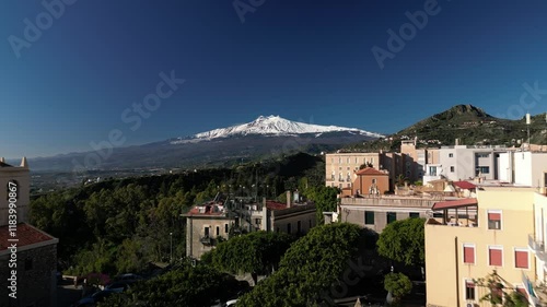 Aerial drone footage of Taormina, Sicily, showcasing the picturesque town, the Mediterranean Sea, and the majestic Mount Etna. Perfect for travel, tourism, and nature-themed projects.