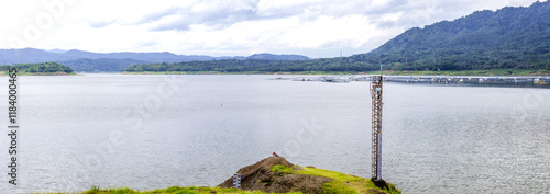 panoramic view of beautiful lake under cloudy sky with fisherman in the frame. Beautiful lake known as Wadas Lintang lake located in Indonesia photo