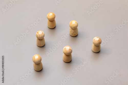 Fotografia Group of Wooden Peg Dolls on Plain Surface Representing Teamwork and Community