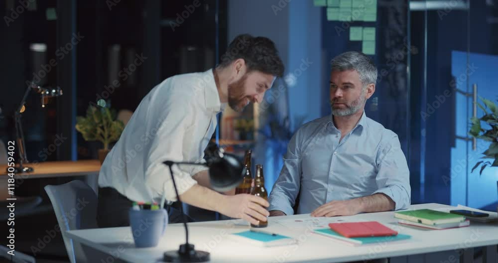 Funny friendly business colleagues coupl e mature men drinking beer staying long hours in office celebrating success at work. Funny friendly business colleagues coupl e mature men drinking beer staying long hours in office celebrating success at work.