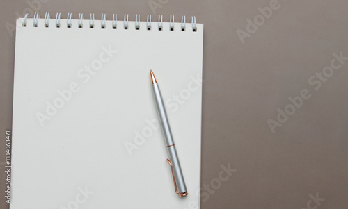 Neutral-toned blank paper note and pen on brown surface, providing a versatile and elegant mockup design. photo