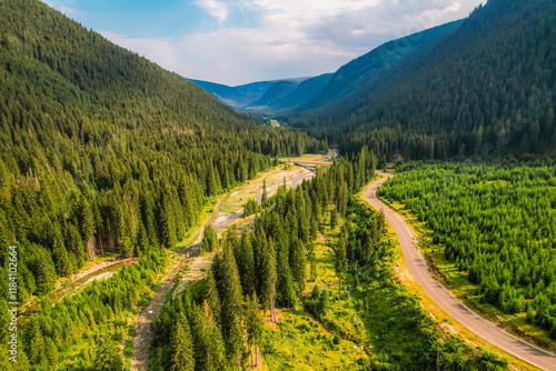 Aerial view of  Transalpina road with many serpentines crossing forest in  Carpathian mountains. Aerial mountains forest trees with road. photo