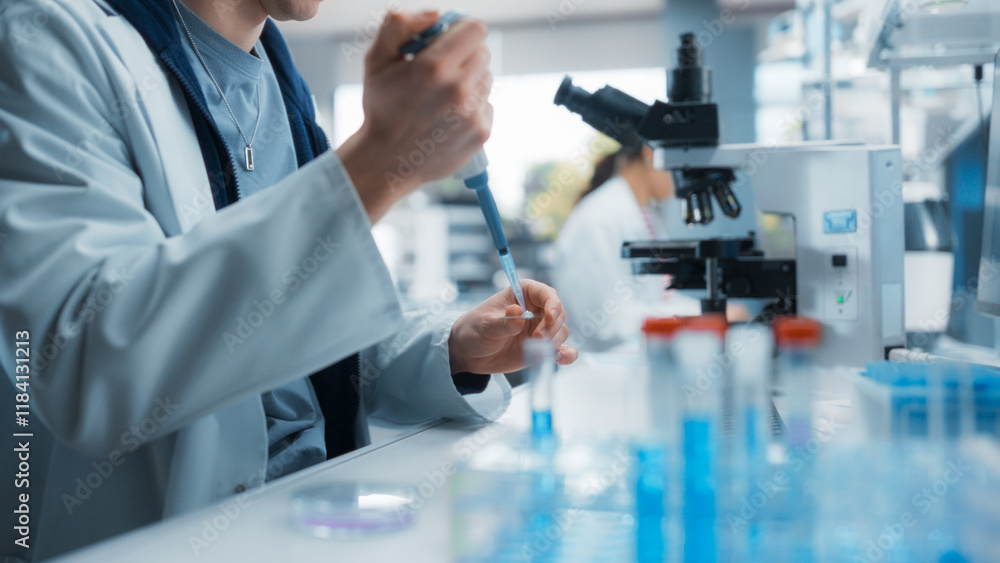 Medical Research Laboratory: Scientist Using Micropipette to Analyze Samples Under Microscope. Advanced Scientific Lab for Medicine, Biotechnology, Microbiology Development Medical Research Laboratory: Scientist Using Micropipette to Analyze Samples Under Microscope. Advanced Scientific Lab for Medicine, Biotechnology, Microbiology Development