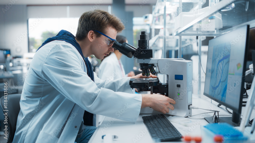 Genetic Research and Development Laboratory: Young Science Student Working on a Computer and Looking at a Sample Under a Microscope. Advanced Biotechnology Lab with Modern Equipment Genetic Research and Development Laboratory: Young Science Student Working on a Computer and Looking at a Sample Under a Microscope. Advanced Biotechnology Lab with Modern Equipment
