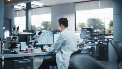 Fotografie Genetic Research and Development Laboratory: Young Science Student Working on a Computer and Using a Microscope