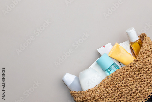 A modern flat lay of multi-colored cosmetic bottles emerging from a sleek bag.
 photo