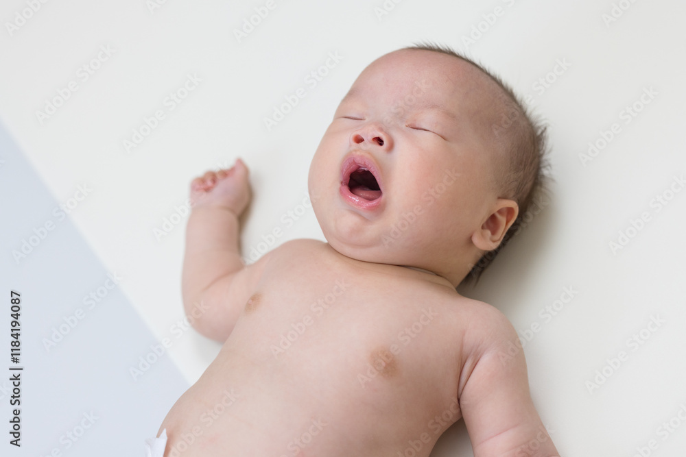 Adorable newborn baby sneezing on soft mat Adorable newborn baby sneezing on soft mat