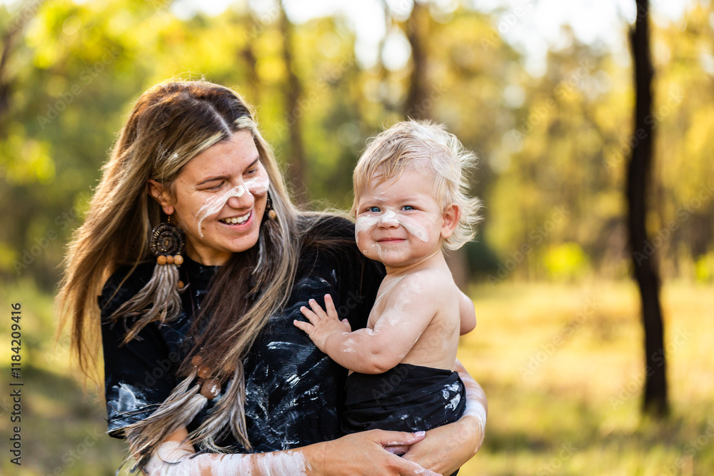 Smiling aboriginal Australian baby with mother in traditional ochre paint in rural bushland Smiling aboriginal Australian baby with mother in traditional ochre paint in rural bushland