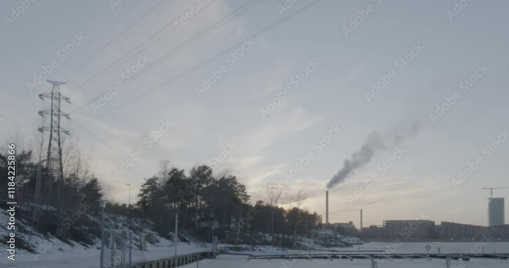 Evening view at Mustikkamaa marina with Kalasatama in the background in winter with sea frozen, Helsinki, Finland. Evening view at Mustikkamaa marina with Kalasatama in the background in winter with sea frozen, Helsinki, Finland.