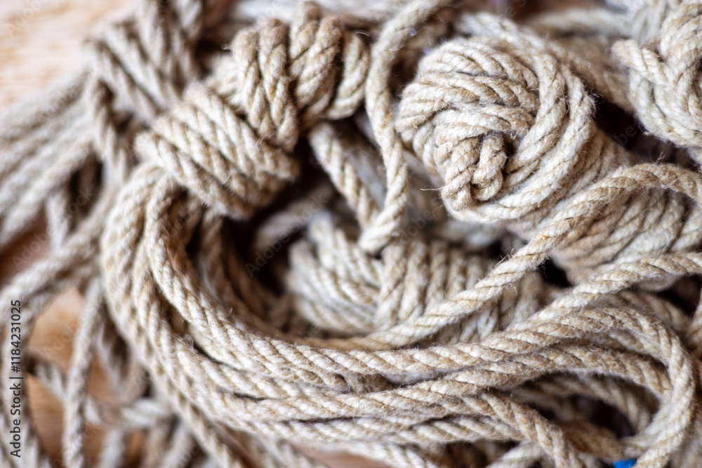 Close-up of natural hemp ropes, neatly coiled and designed for artistic and secure bondage, showcasing their texture and organic material. Close-up of natural hemp ropes, neatly coiled and designed for artistic and secure bondage, showcasing their texture and organic material.