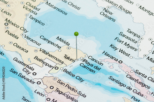 Macro photo of a green pin needle into Tulum city of Mexico political map 
