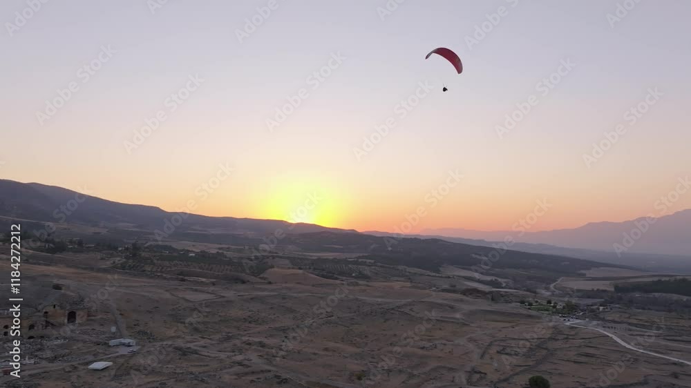 Aerial view of the travertines of Pamukkale at sunrise with paragliders soaring above, Pamukkale, Turkey. Aerial view of the travertines of Pamukkale at sunrise with paragliders soaring above, Pamukkale, Turkey.
