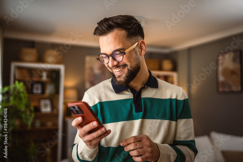 Fotografie portrait of adult man stand and use mobile phone at home