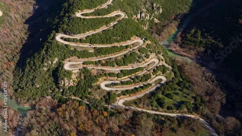 Aerial view of serpentine road winding through lush greenery and forested mountains, Papigko Pass, Epirus, Greece. photo