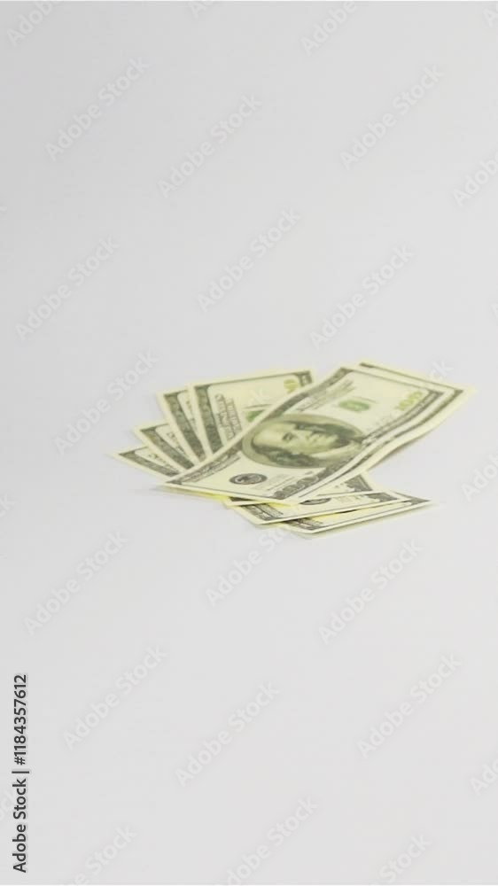 Slow motion. Few Dollars banknotes rain fall on white surface cyclorama. 100 nominal Vertical Shot. Slow motion. Few Dollars banknotes rain fall on white surface cyclorama. 100 nominal Vertical Shot.