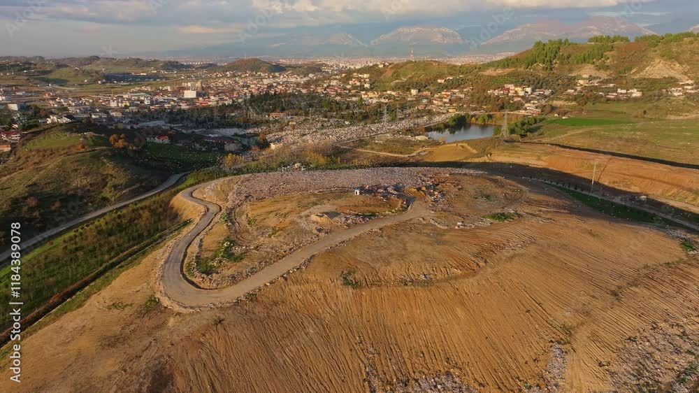 Aerial view of a vast landfill filled with rubbish and garbage, surrounded by mountains and greenery, Tirana, Albania. Aerial view of a vast landfill filled with rubbish and garbage, surrounded by mountains and greenery, Tirana, Albania.