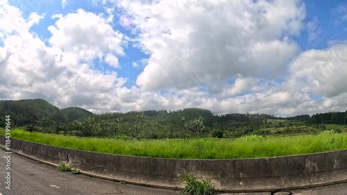 Car ride along the road on a sunny day with lots of clouds in the sky and intense car and truck traffic. During a holiday.