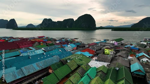 Aerial view of colorful rooftops of Panyee floating village surrounded by serene water and mountains, Phang Nga, Thailand. photo