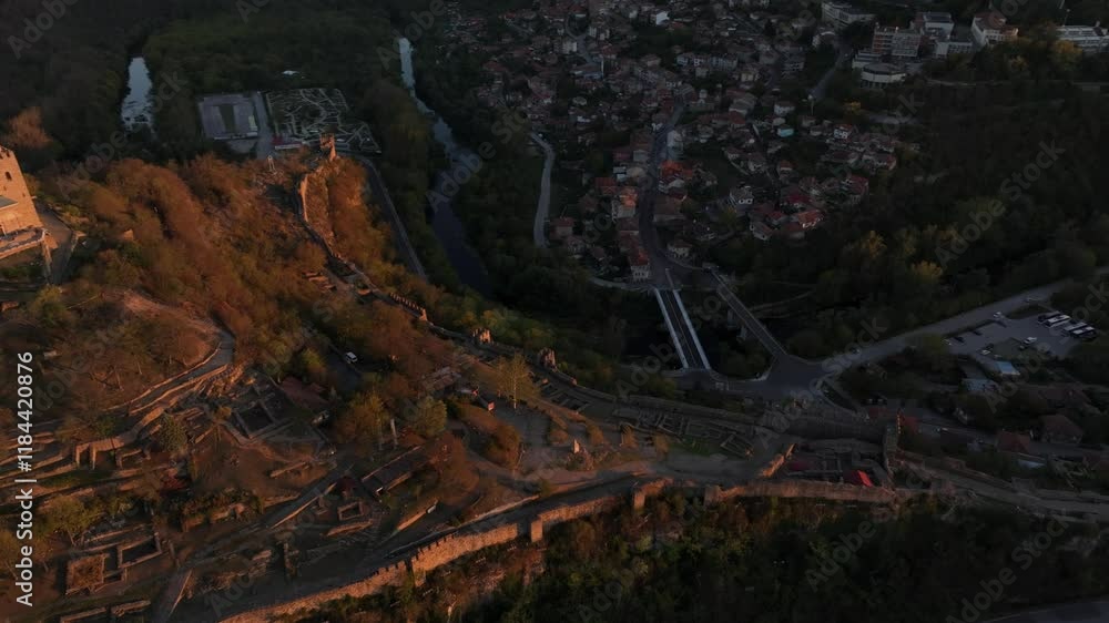 Aerial view of tsarevets fortress at sunset with scenic cityscape and river in a beautiful valley, Veliko Tarnovo, Bulgaria. Aerial view of tsarevets fortress at sunset with scenic cityscape and river in a beautiful valley, Veliko Tarnovo, Bulgaria.