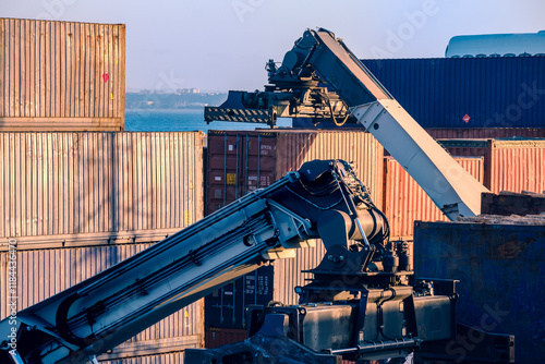 Obraz na płótnie Reach stacker arm handling shipping containers at a port facility w salonie