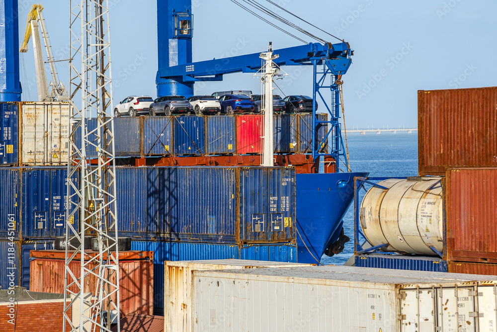 Cargo and tank containers stacked and with vehicles on top stacked at