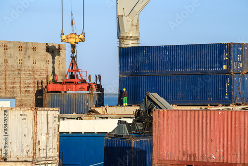 Obraz na płótnie Workers handle crane loading cargo containers at a shipping terminal w salonie