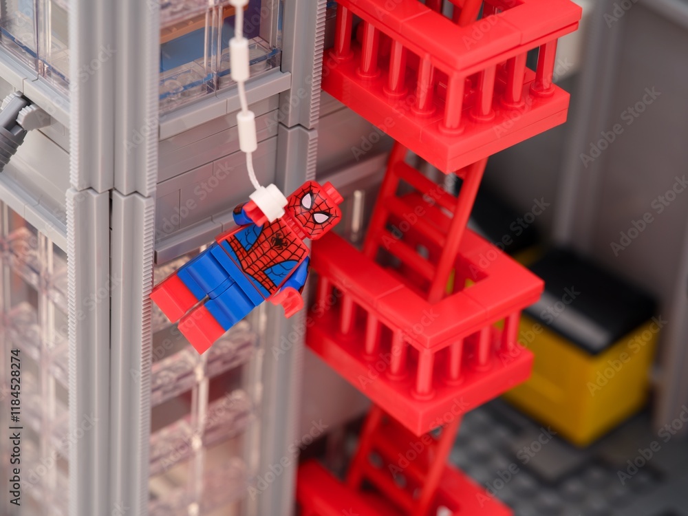 Fototapeta premium Tambov, Russian Federation - January 06, 2025 Lego Spiderman minifigure hanging from a web off the side of The Daily Bugle