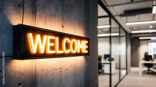 Neon Welcome sign hanging on wall at the entrance to modern office with open space. Onboarding of new employees, welcome to the team, new job