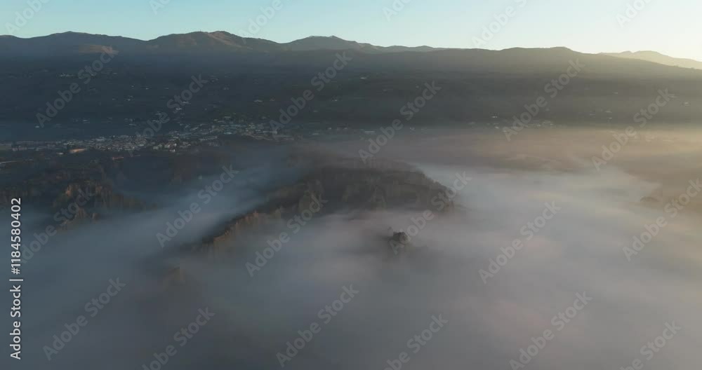 Aerial view of serene mountains shrouded in fog over a picturesque valley, Tuscany, Reggello, Italy. Aerial view of serene mountains shrouded in fog over a picturesque valley, Tuscany, Reggello, Italy.