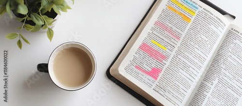 Coffee, plant, and open book with highlighted text on white background.