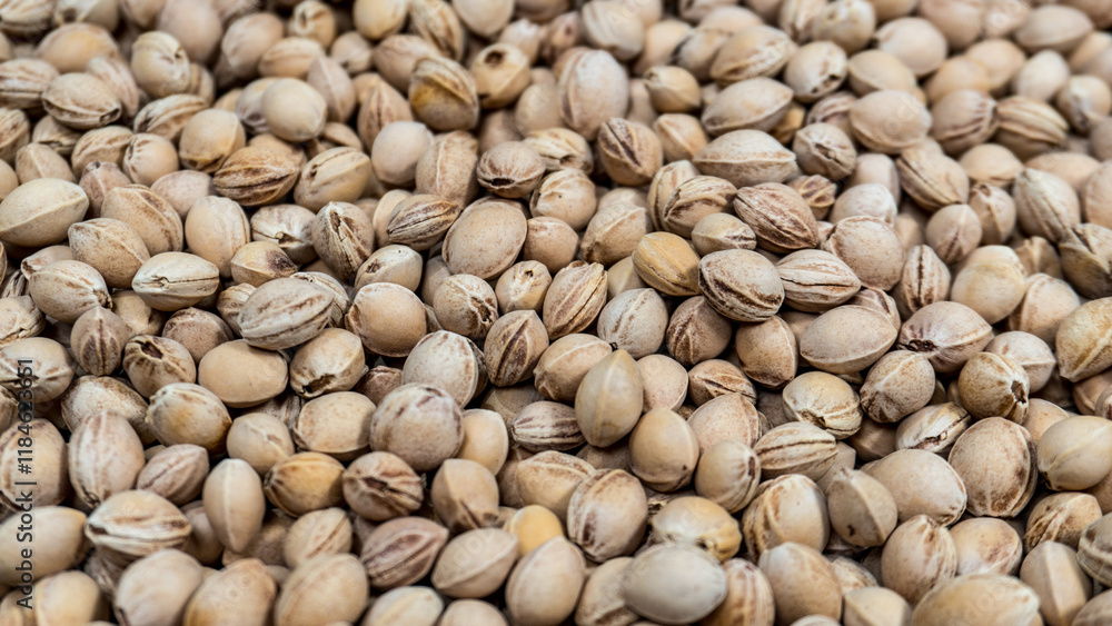A dense layer of kernels fills the frame. Oval shapes with visible ridges. Light brown tones dominate. Textures and patterns are clearly visible. The image shows natural, raw materials A dense layer of kernels fills the frame. Oval shapes with visible ridges. Light brown tones dominate. Textures and patterns are clearly visible. The image shows natural, raw materials