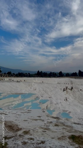 Pamukkale's white travertine terraces filled with thermal pools under a dramatic sky in Turkey